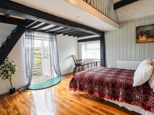 a bedroom with a bed and a large window at Cae Gogrydd in Machynlleth