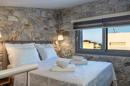 um quarto com uma cama grande e toalhas em THALASSIA LUXURY APARTMENTS em Stavros