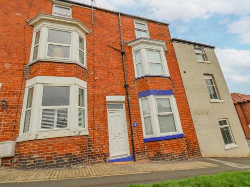 a red brick building with a white door and windows at 3 Auborough Street in Scarborough