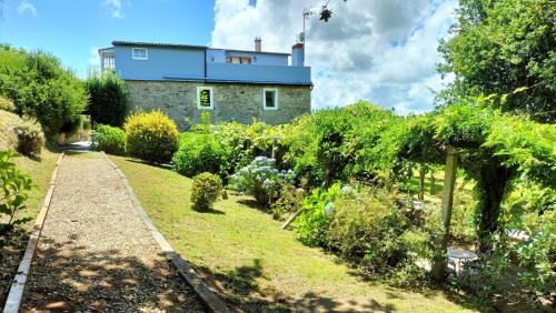 a house with a garden in front of it at As Seis Chemineas in San Xulián de Sales