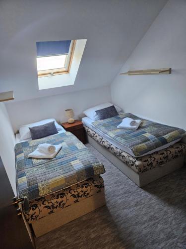 two beds in a small room with a window at Villa Florencia in Bardejov