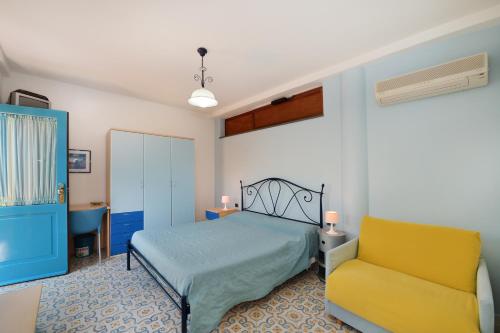 a bedroom with a bed and a yellow chair at La Capannina in Procida