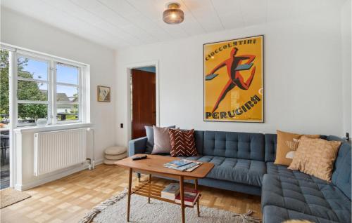 a living room with a blue couch and a table at Lovely Home In Samsø With Wifi in Ballen