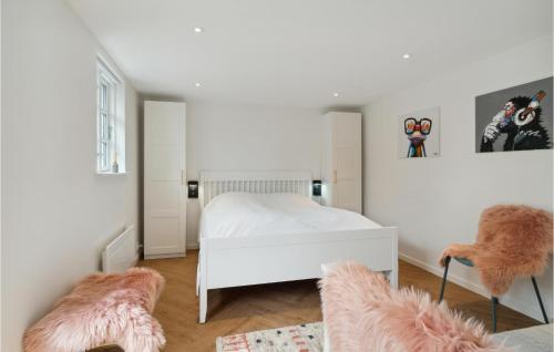a bedroom with a white bed and two furry chairs at Lovely Home In Samsø With Wifi in Ballen
