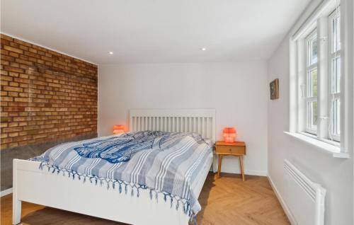 a bedroom with a bed and a brick wall at Lovely Home In Samsø With Wifi in Ballen