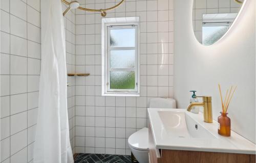 a white bathroom with a sink and a window at 3 Bedroom Lovely Home In Sams in Ballen