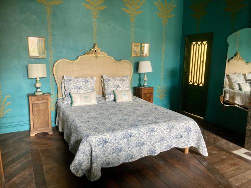1 dormitorio con 1 cama grande y paredes azules en Gogascony en Lavit