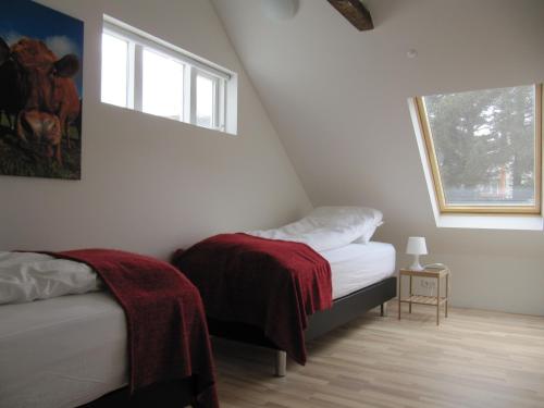 a small bedroom with two beds and a window at Grand-Inn Bar and Bed in Sau&eth;&aacute;rkr&oacute;kur