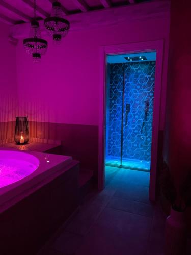 a purple bathroom with a tub and a door at L’ Aia del Principe in Montepulciano