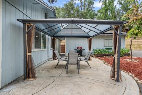 a pergola with a table and chairs on a patio at Sweet Haven - Home with EV Charger near Yosemite in Groveland