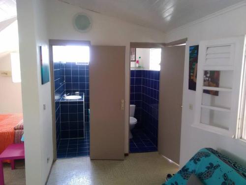 y baño con aseo y ducha de azulejos azules. en Studio 2-ème étage Cœur de Saint-François, en Saint-François
