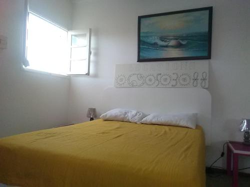 1 dormitorio con cama amarilla y ventana en Studio 2-ème étage Cœur de Saint-François, en Saint-François