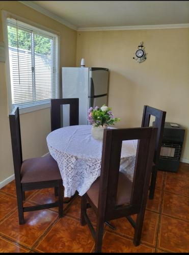 La cuisine est équipée d'une table, de chaises et d'un réfrigérateur. dans l'établissement Cabañas Barrancas, à San Antonio