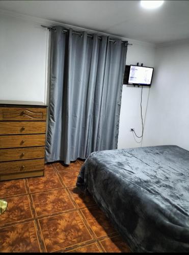 - une chambre avec un lit, une commode et une télévision dans l'établissement Cabañas Barrancas, à San Antonio