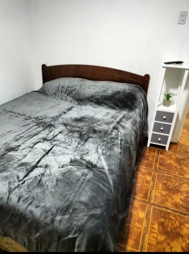 - un lit avec une couette noire dans une chambre dans l'établissement Cabañas Barrancas, à San Antonio