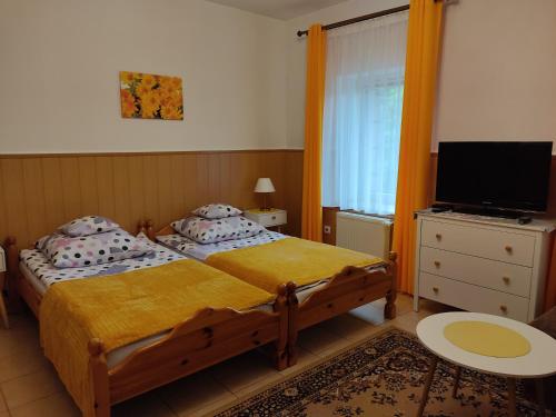 a bedroom with a bed and a flat screen tv at MAGNOLIA Duszniki Zdrój in Duszniki Zdrój