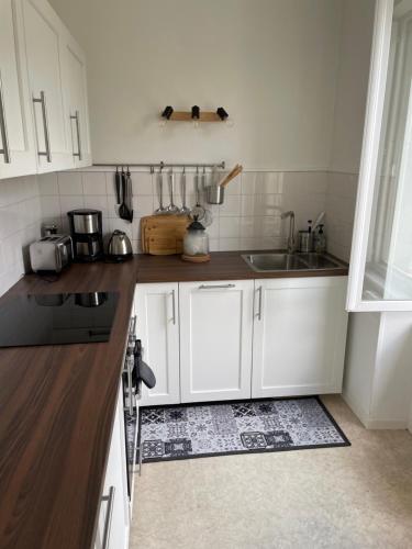 a kitchen with white cabinets and a sink at Appartement en coeur de ville 2 personnes in Bort-les-Orgues