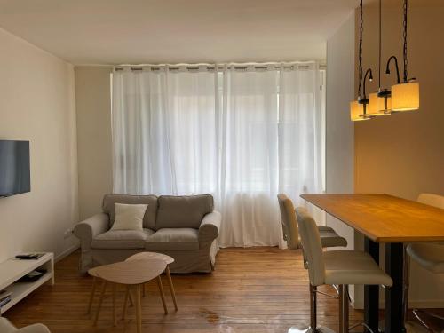 un salon avec un canapé et une table dans l'établissement Appartement Suzon en coeur de ville 2 personnes, à Bort-les-Orgues