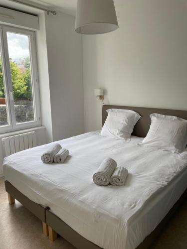 a bed with towels on top of it with a window at Appartement en coeur de ville 2 personnes in Bort-les-Orgues