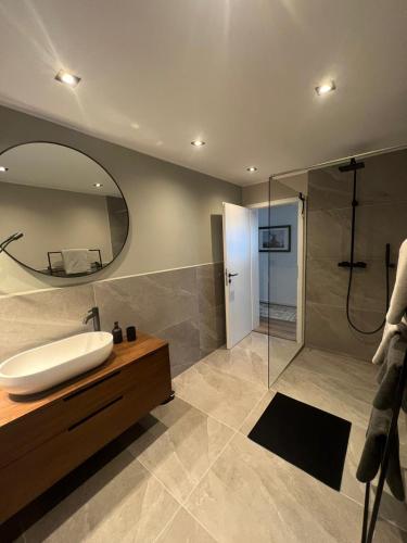 a bathroom with a sink and a shower with a mirror at Bergerwachen in Berchtesgaden