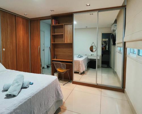 1 dormitorio con cama, escritorio y espejo en BH PARA 2 - STUDIO - Estoril, en Belo Horizonte