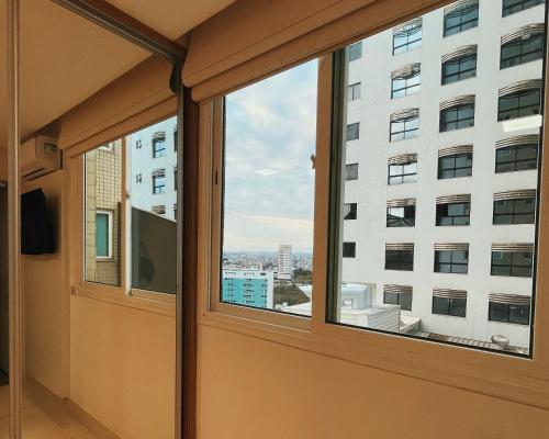 ventana en una habitación con vistas a un edificio en BH PARA 2 - STUDIO - Estoril, en Belo Horizonte