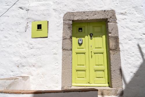 a yellow door on the side of a building at Vintage White House Patmos in Patmos