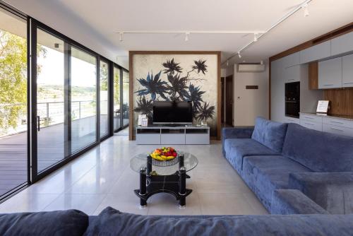 a living room with a blue couch and a tv at Lemon Resort Spa in Gródek Nad Dunajcem