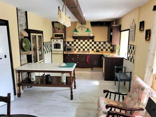 a living room with a table and a kitchen at As Seis Chemineas in San Xulián de Sales