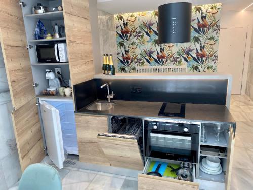 a small kitchen with a sink and a microwave at AIRVA: Apartamentos Bajada de la Libertad in Valladolid