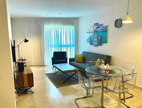 uma sala de estar com um sofá e uma mesa de vidro em Okeanos Bmarina em Herzliya B