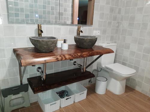 a bathroom with two sinks and a toilet at As Seis Chemineas in San Xulián de Sales