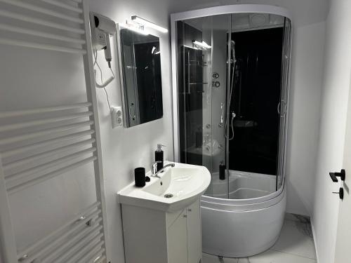 a white bathroom with a sink and a shower at Zeus in Cluj-Napoca