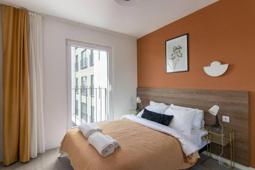 ein Schlafzimmer mit einem großen Bett und einer orangefarbenen Wand in der Unterkunft Sophisticated 2BR Corner Haven w/ Parking & Gym #131 in Istanbul