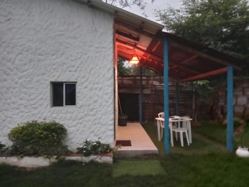 a white house with a table and a patio at Portón Azul in Montañita