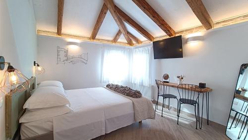 Schlafzimmer mit einem Bett und einem Tisch mit Stühlen in der Unterkunft Casa Cuccagna Chioggia - Vista Canal Vena in Chioggia