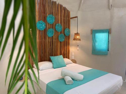 um quarto com uma cama grande e almofadas azuis em Isabella Boutique Hotel em Playa del Carmen