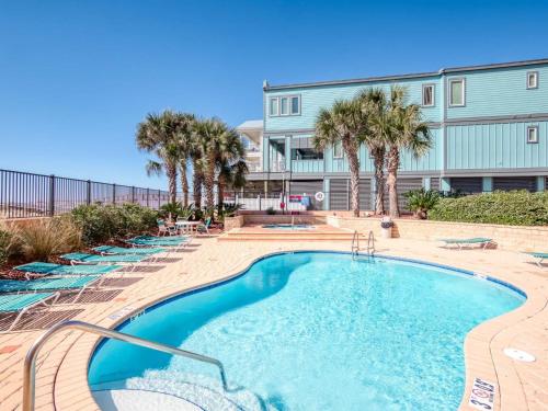 una piscina con palmeras frente a un edificio en Seachase 803W by Vacation Homes Collection en Orange Beach