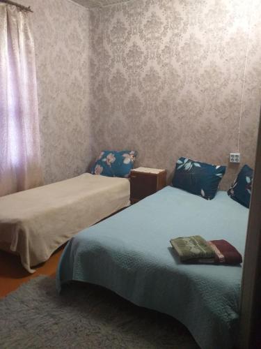 two beds in a small room with blue sheets at Talsu nov Kolka Kopmītne 1-18 in Kolka