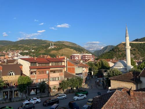 a city with cars parked in a parking lot at Blerta's apartment in Prizren