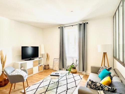 a living room with a couch and a tv at Maison EL&AR - Place de la Comédie, Wifi in Montpellier