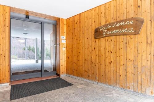 une entrée dans un bâtiment avec un panneau sur le mur dans l'établissement Val di Luce Foemina RB, à Abetone