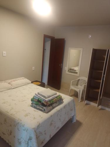 a bedroom with a bed with a table and a chair at Casa de Praia in Balneário Gaivotas