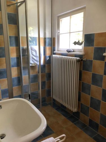 La salle de bains est pourvue d'une baignoire, d'une fenêtre et d'un radiateur. dans l'établissement Ferienwohnung Beim Bienagassl, à Waldsassen