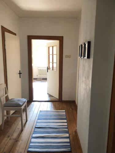 a hallway with a door and a chair and a rug at Ferienwohnung Beim Bienagassl in Waldsassen