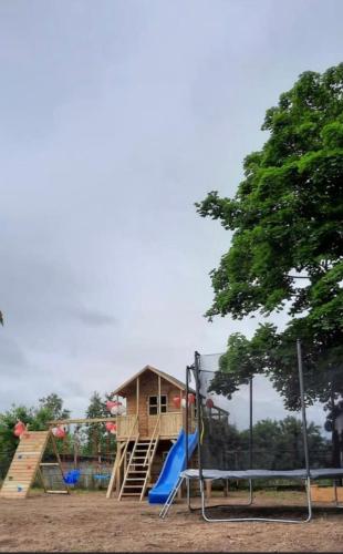 a playground with a slide and a house at Rajskie wzgórze w Karkonoszach in Łomnica