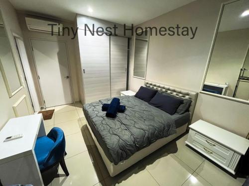 um quarto com uma cama e uma cadeira azul em Tiny Nest Homestay - iCity Shah Alam with Free WIFI, 5 minutes to UITM em Kampong Padang Jawa
