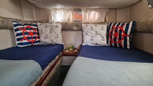 a bedroom with two beds and pillows in a room at Sea & Tasty - Boat House in Ponta Delgada