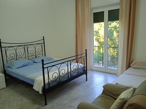 a bedroom with a bed and a couch and a window at Milky's House in Isola del Cantone