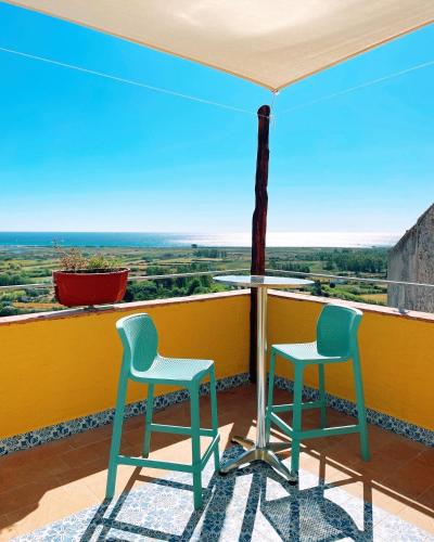 two chairs sitting on a balcony with a view at LOFT CON USO CUCINA E TERRAZZO PANORAMICO - FORA E' MUROS II - Ammentos Posada in Posada
